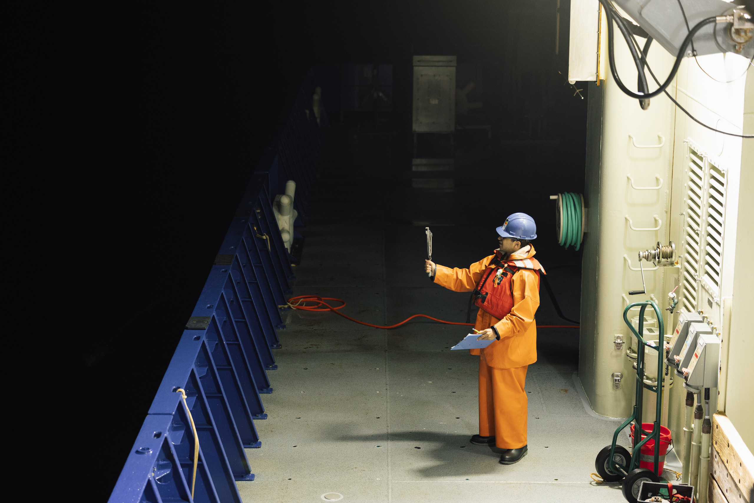 Scientist working on deck during a night shift at sea.